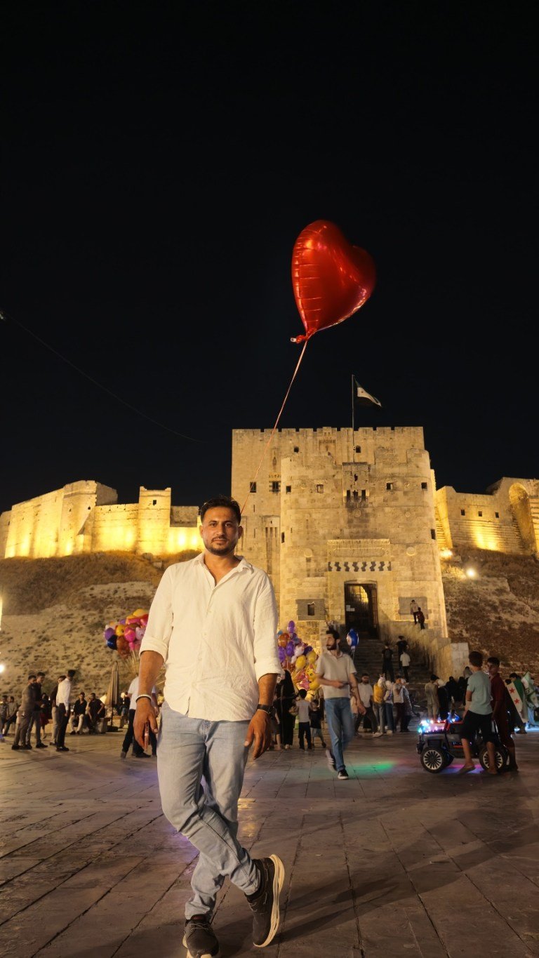 Abdulrahman met een rode hartballon voor een historische citadel